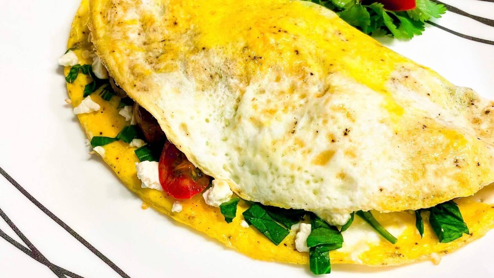 egg omelet filled with spinach, tomatoes, and feta cheese