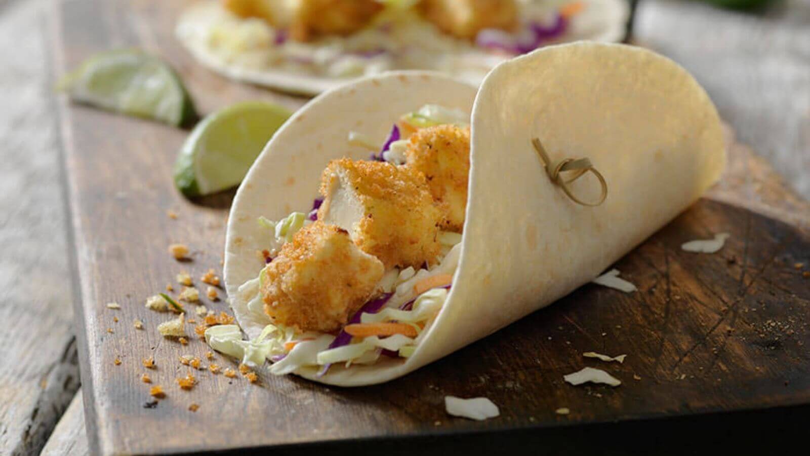 soft taco shell filled with crispy tofu pieces and coleslaw mix