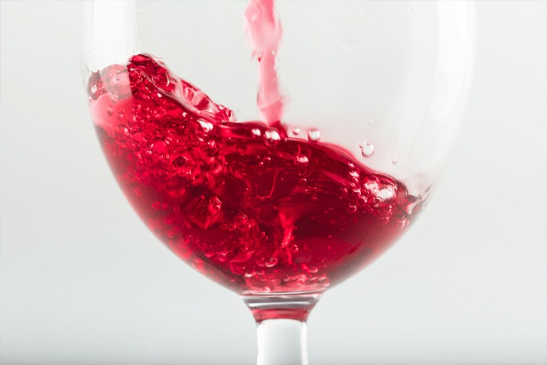 Mixed Fruit Punch getting poured into a wine glass.